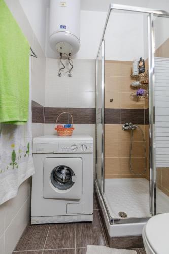 a bathroom with a washing machine and a shower at Kalifteri Beach House in Afissos