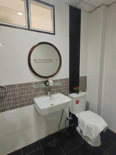 a bathroom with a sink and a mirror and a toilet at The Rich Room ห้องพักโคราช in Ban Pra Dok