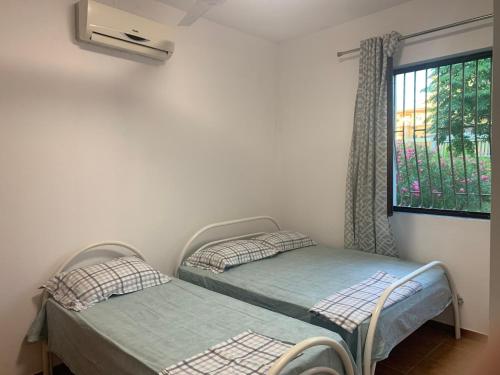 two twin beds in a room with a window at Velipoja Sea House in Velipojë