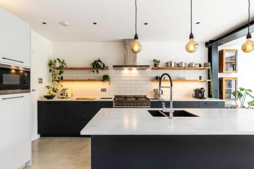 a kitchen with black cabinets and a sink at Spacious and Charming Brixton Home in London