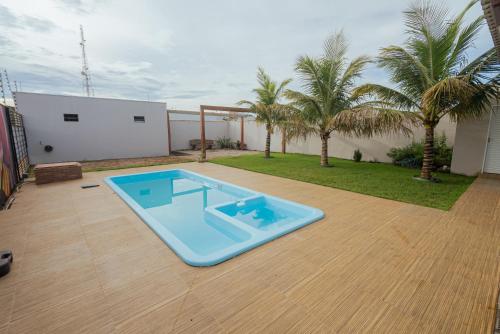 a swimming pool in a yard with palm trees at Iron House in Chapada dos Guimarães