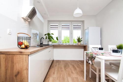 a kitchen with white cabinets and a wooden counter top at Modern Apartament Chełm 2 sypialnie in Chełm