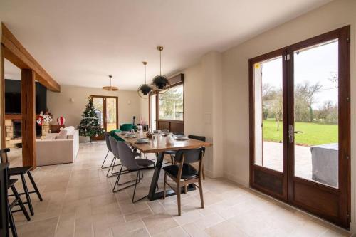 une cuisine et une salle à manger avec une table et des chaises dans l'établissement Maison famille-10 min Deauville, à Saint-Étienne-la-Thillaye