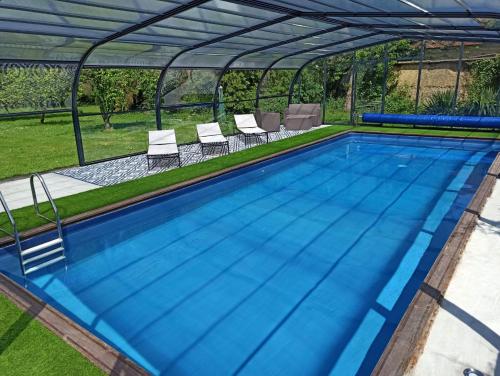 an overhead view of a swimming pool with a roof at La Petellerie, maison de campagne avec piscine pour un séjour détente in Moyon