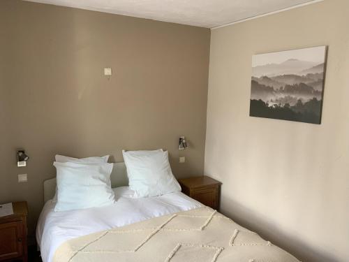 1 dormitorio con 1 cama con sábanas blancas en Au cœur bion en Bouillon