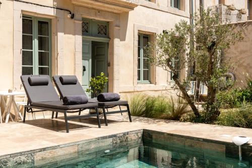 ein Paar Stühle neben einem Pool in der Unterkunft La Grande Maison Chambres d'Hôtes in Peyriac-de-Mer