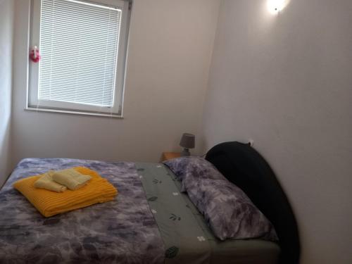 a bedroom with a bed with a bed frame and a window at Apartment with two bedrooms in Glogošnica