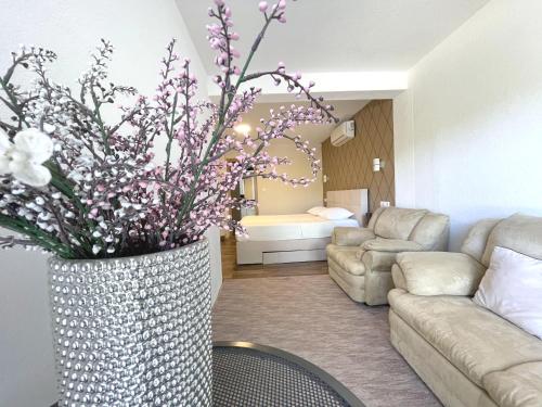a living room with a couch and a vase with flowers at Villa Sarajevo in Vareš
