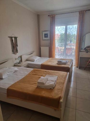 a hotel room with three beds and a window at Hotel Nautilos in Sozopoli