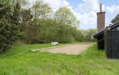 a dirt field in the grass next to a building at Three-Bedroom Holiday Home In Fano in Fanø
