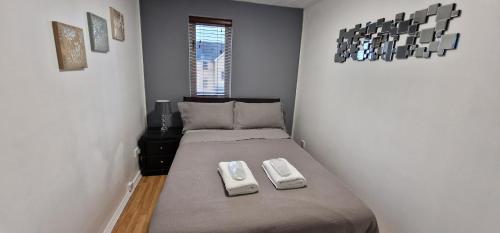 een kleine slaapkamer met een bed en een raam bij Modern 2 Bedroom Apartment in Londen