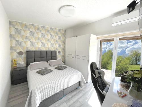 a bedroom with a bed and a large window at Villa Sarajevo in Vareš