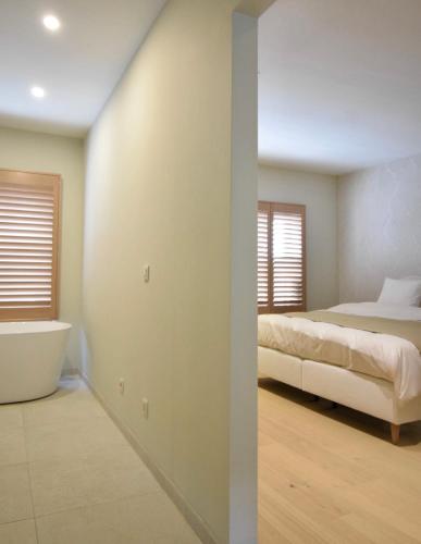 a bedroom with a bed and a bath tub at Nova Nocte in Tongeren