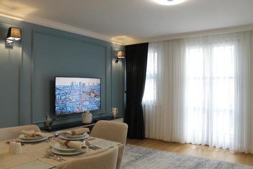 a living room with a table and a television on a wall at Garlon Residence in Istanbul