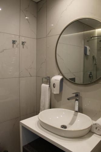 a white bathroom with a sink and a mirror at Garlon Residence in Istanbul