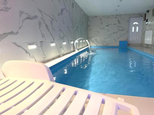 a swimming pool with a white bench next to it at Villa Sarajevo in Vareš