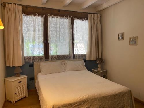 San Giorgio Di MantovaにあるAgriturismo Corte Roccaのベッドルーム1室(ベッド1台付)、窓(カーテン付)