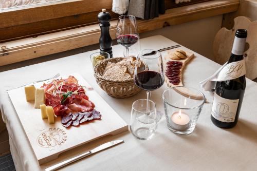 a table with a plate of food and a bottle of wine at Hotel Baer & Post Zernez in Zernez