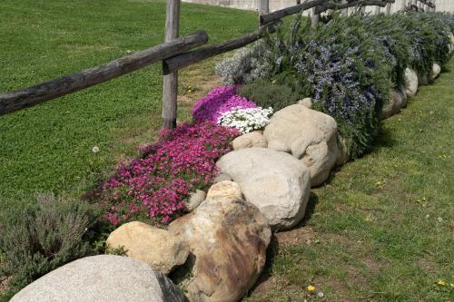 a garden with flowers and rocks next to a fence at M-APPHOTEL in Benna
