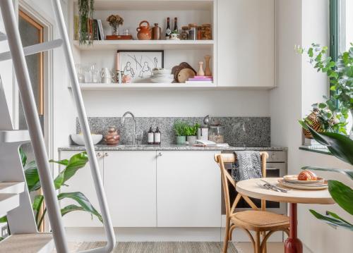 a kitchen with white cabinets and a table at Mason & Fifth, Bermondsey in London