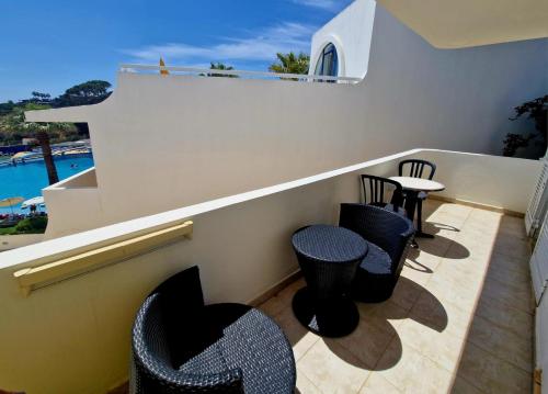 a balcony with chairs and a table on a balcony at Praia Oura Sunset in Albufeira