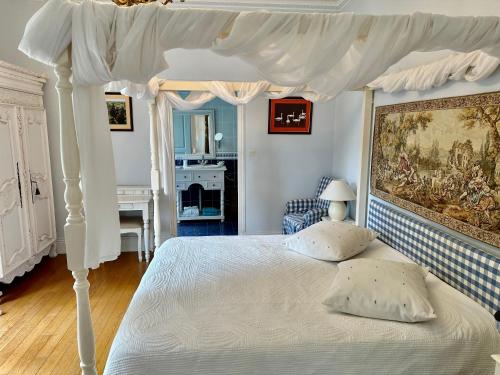 1 dormitorio con 1 cama blanca con dosel en Château Les Vallées, en Tournon-Saint-Pierre