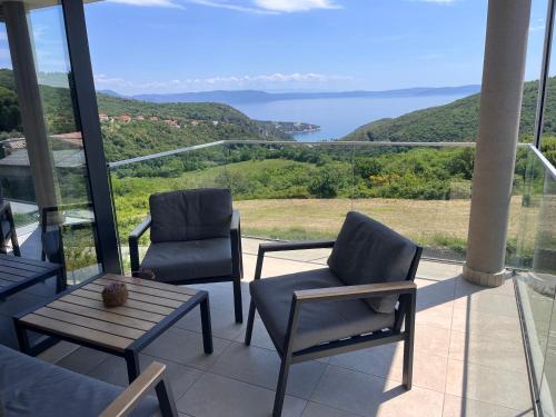 two chairs and a table on a balcony with a view at Merlo APP in Labin