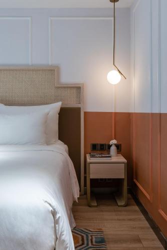 a bedroom with a bed and a table with a lamp at Hanoi Le Jardin Hotel & Spa in Hanoi