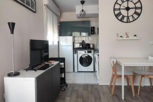 une cuisine avec une table et une horloge au mur dans l'établissement Large studio in the heart of Caen, à Caen