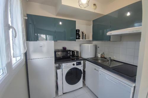 Il comprend une cuisine équipée d'un réfrigérateur blanc et d'un lave-linge. dans l'établissement Large studio in the heart of Caen, à Caen