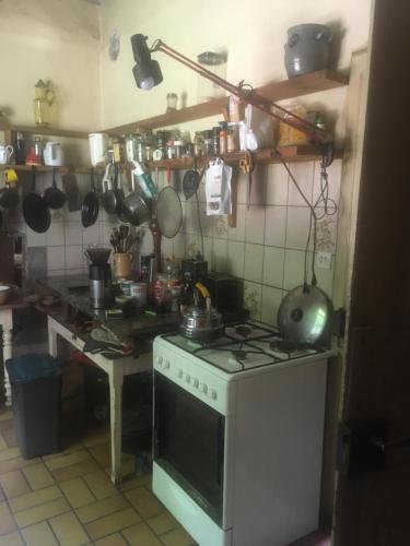 Il comprend une cuisine équipée d'une cuisinière et d'un comptoir avec des casseroles et des poêles. dans l'établissement Les anciens thermes, à Soultzbach-les-Bains