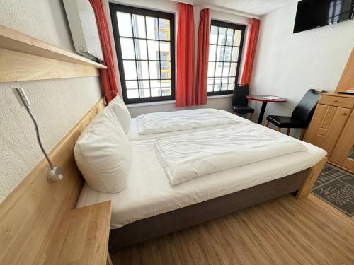 a bedroom with a bed in a room with windows at Aalreuse in Rostock