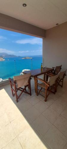 a dining room with a table and chairs and the ocean at Villa Dina Apartments in Almirida