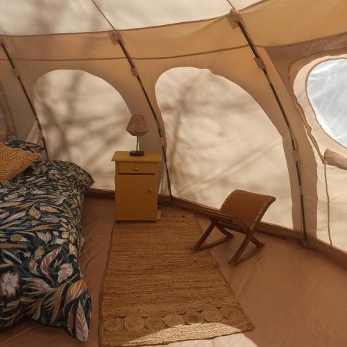 a tent with a bed and a chair in it at ECO CEIBA in Busque