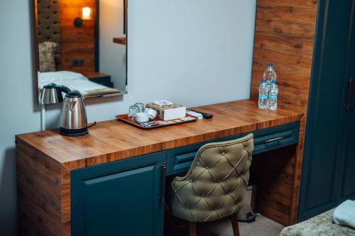einen Waschtisch mit einem Spiegel und einem Stuhl in einem Zimmer in der Unterkunft Mysia Olympos Hotel in Bursa