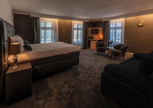 a hotel room with a bed and a couch at Square Boutique Hotel & Brasserie in Venray