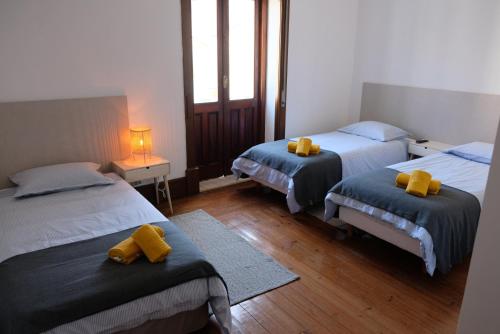 um quarto com 2 camas com toalhas amarelas em Yellow Inn Aveiro em Aveiro