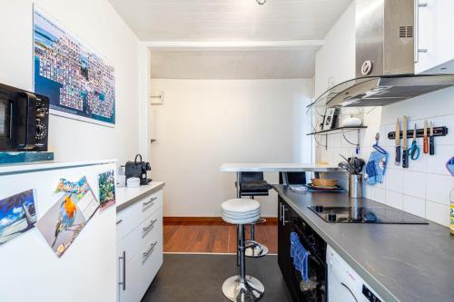 une cuisine avec des armoires blanches et un comptoir dans l'établissement GuestReady - Bright retreat near Belleville, à Paris