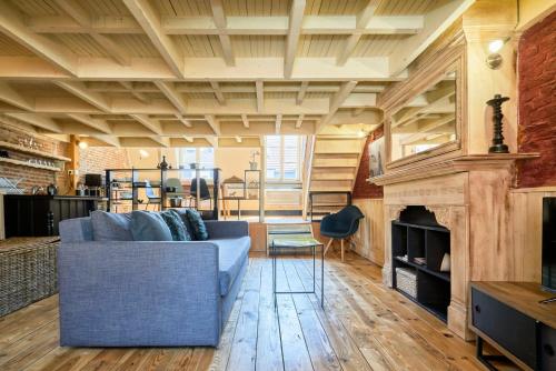 un salon avec un canapé bleu et une cheminée dans l'établissement Old Lille apartment with terrace, à Lille