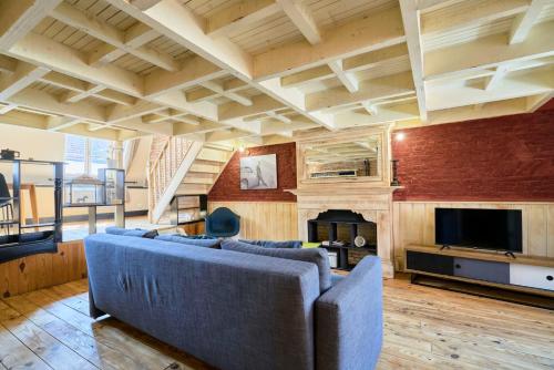 un salon avec un canapé bleu et une cheminée dans l'établissement Old Lille apartment with terrace, à Lille