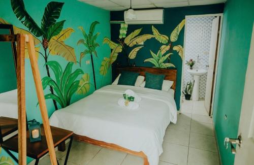 um quarto com uma cama com papel de parede tropical em Hostel Travelers Santiago em Santiago