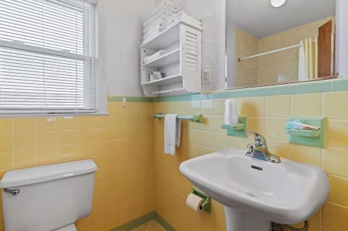 a bathroom with a white toilet and a sink at Cavalier by the Sea in Kill Devil Hills