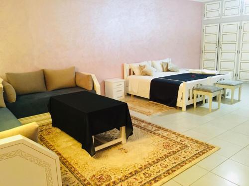 a living room with a bed and a couch at Riad Nasma Souihla in Marrakech