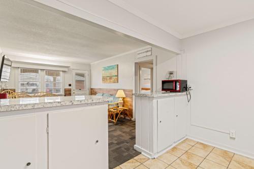 a kitchen and living room with a counter and a microwave at Cavalier by the Sea in Kill Devil Hills