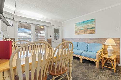 a living room with a blue couch and chairs at Cavalier by the Sea in Kill Devil Hills