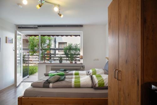 a bed in a room with a large window at Apartment Biendl in Mittenwald