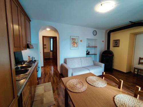 a kitchen and living room with a table and a couch at Casa Relax in Bellano