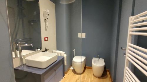 a bathroom with a sink and a toilet and a mirror at Zi Bitta - guest house in Palmanova
