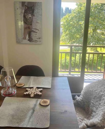 une table à manger avec une photo d'un chat sur le mur dans l'établissement Appartement á Megève, à Demi-Quartier