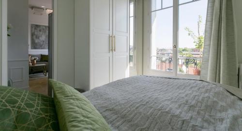 une chambre avec un lit et une grande fenêtre dans l'établissement Appartement de charme près de La Défense, à Colombes